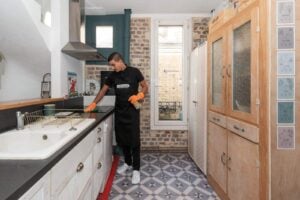 homme de menage nettoyant la cuisine avant la vente de la maison