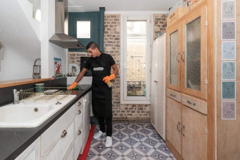 homme de menage nettoyant la cuisine avant la vente de la maison